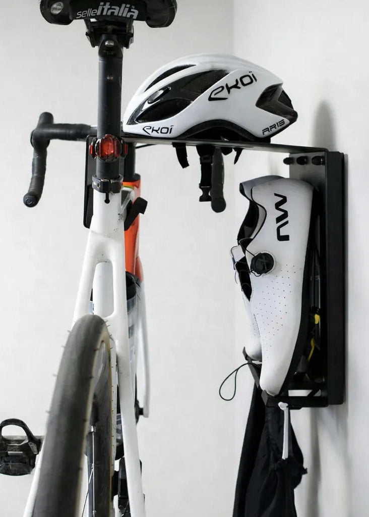 Soporte de pared para bicis negro, foto lateral con equipamiento colgado